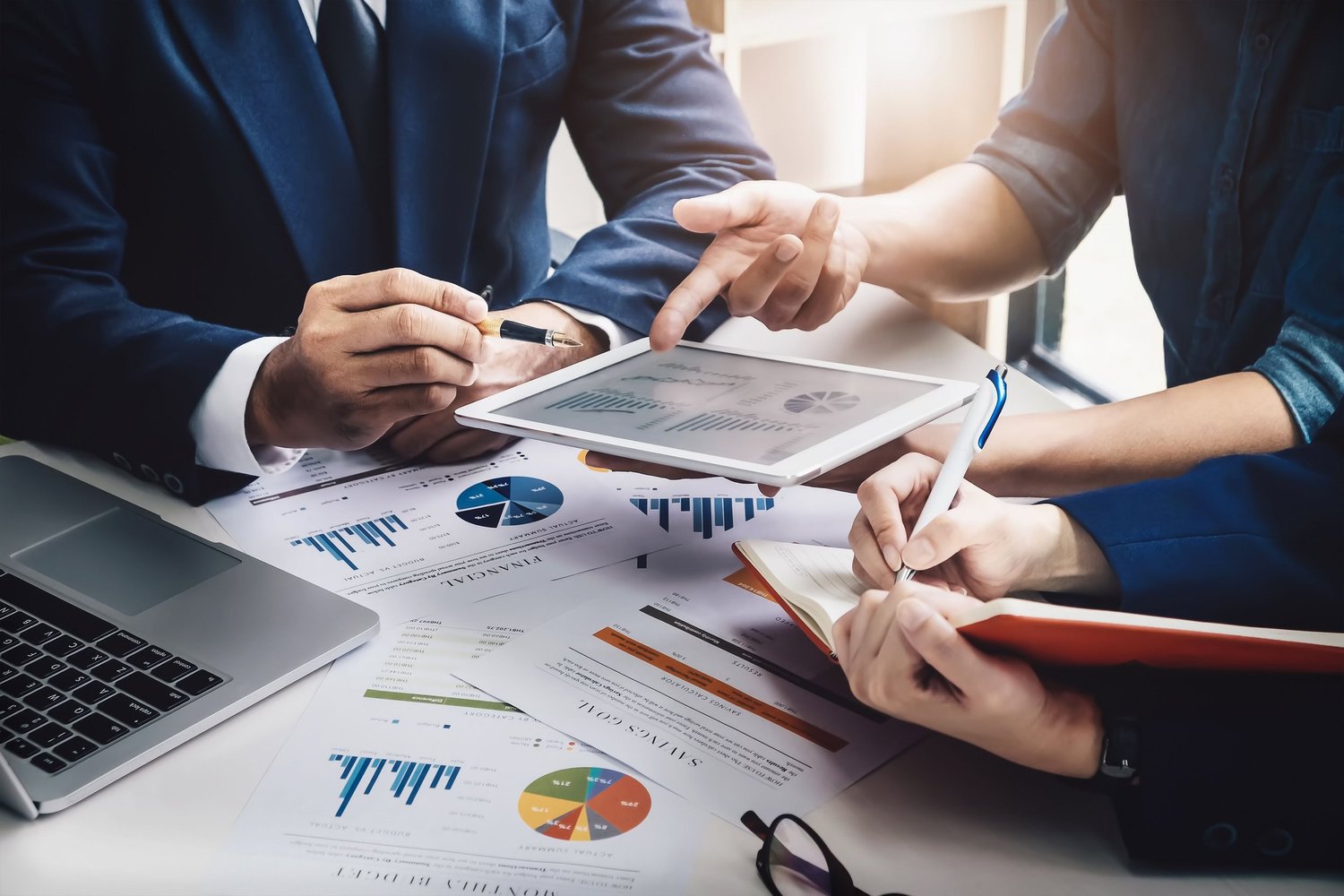 Business meeting with people discussing charts and graphs on documents.